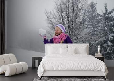 child with snowball in winter forest Wall mural