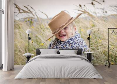 smiling girl with hat in head in autumn grass Wall mural