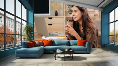 Female entrepreneur reading new business project on laptop and d Wall mural