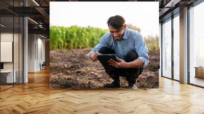 Smart farmer using digital tablet to examining quality of soil f Wall mural