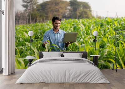 Smart farmer using laptop to examining quantity and quality crop Wall mural