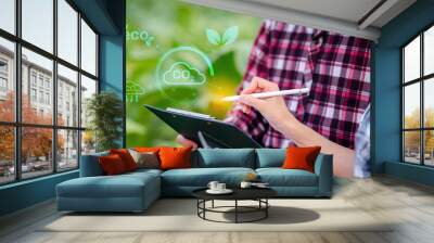 Two agricultural couple are looking checklist at a computer screen with a green circle chart of reduce co2 in farm Wall mural