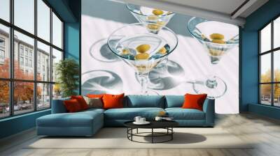 Fresh home made vodka martini with olives in cocktail glasses on white background with shadows. Wall mural