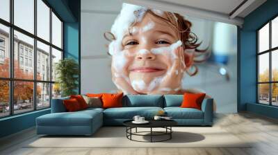 Smiling kid taking a bath and applies soft foam on face in bathroom Wall mural