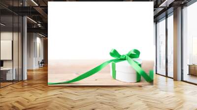 Gift box with green ribbon on wooden floor isolated on white Wall mural