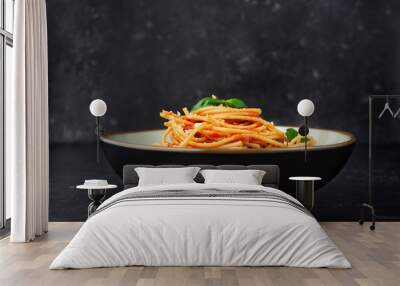 A plate with pasta in tomato sauce on black background Wall mural