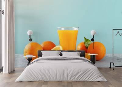 Fresh orange juice glass and oranges on blue background Wall mural