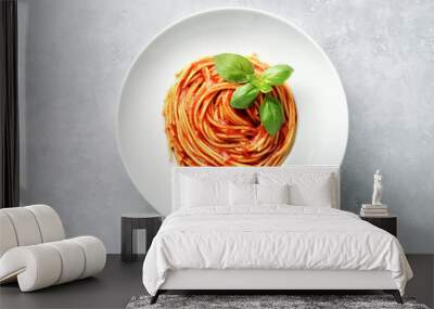 Top view of plate with spaghetti in tomato sauce and basil on white background Wall mural