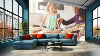 Mother and daughter baking cookies in a bright kitchen Wall mural