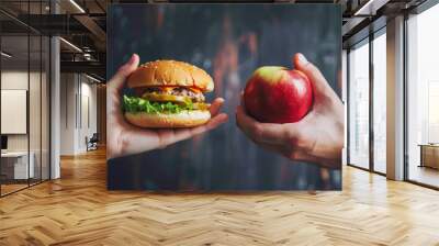 Unhealthy vs healthy food. Burger and apple in different hands. Choice between fast foods and vegetables, fruit. Wall mural