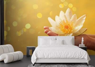 close-up of a white lotus in female hands on a yellow background with glitter and copy space Wall mural