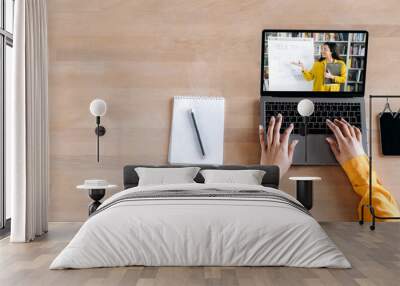 E-learning, online education, webinar. Top view on laptop screen on the desk, with female caucasian smart teacher, conducts an online lesson by video conference, stands near whiteboard. Copy space Wall mural