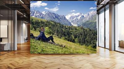 Man is sitting and enjoying views of the Caucasus Mountains. Wall mural