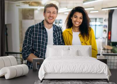 Portrait of business coworkers or student friends. Handsome caucasian man and beautiful african american woman work or study together, colleagues look at the camera, smiling Wall mural