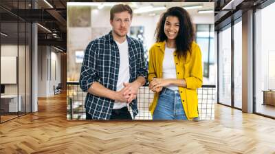 Portrait of multiethnic friends students or coworkers in stylish wear at the workplace. Happy young adult successful male and female employee looking at the camera, smiling, work or study together Wall mural