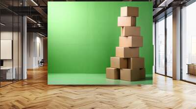 Tower made of cardboard boxes. Green background. Copy space. Wall mural