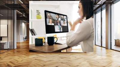 Video call. Remote work. A girl work from home. She communicate via video communication with colleagues using computer Wall mural