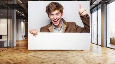 Young man giving a thumbs up while holding a blank sign promotion advertisement sale mockup Wall mural