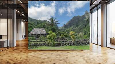 A grass roof hut, palm tree, mountains and lush garden, at the Limahuli Garden and Preserve-National Botanical Garden, Ha'ena, Halele'a, Kauai, Hawaii Wall mural