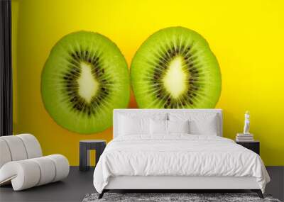 two halves of kiwi on a yellow background. Wall mural