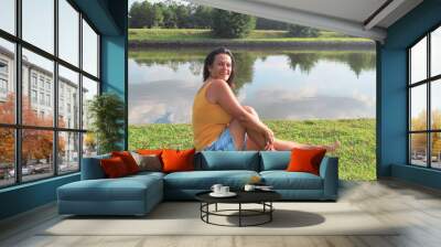 woman sitting on grass in the park Wall mural