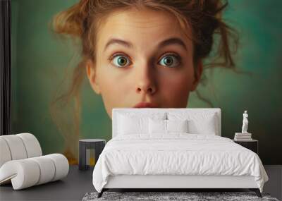 girl expresses emotion of surprise on light green background. Portrait of emotional girl Wall mural