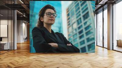 Young attractive woman in glasses and office suit stands against modern city, bright and attractive advertising photo. Wall mural