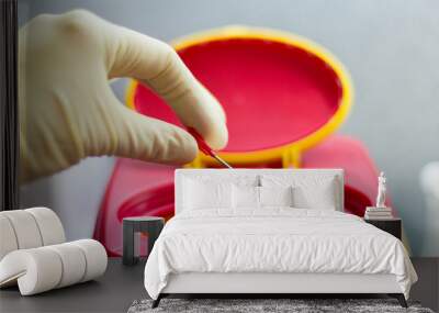 a hand takes a needle in a medical bin Wall mural