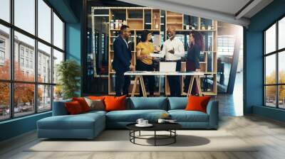 Planning brings everyone together. Shot of a group of designers having a discussion in a modern office. Wall mural