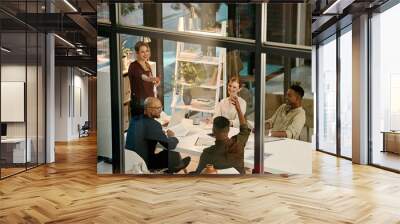 Businesspeople in a marketing growth strategy discussion in a collaboration meeting using teamwork inside a modern office. Mindset development and team building by diverse, smart and creative adults Wall mural