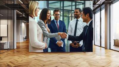 Its an honour to be working alongside the best. Shot of businesspeople shaking hands in an office. Wall mural