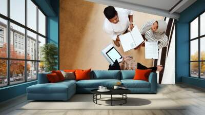 Tackling some reports as a team. High angle shot of a group of businesspeople having a discussion while going through paperwork together in an office. Wall mural