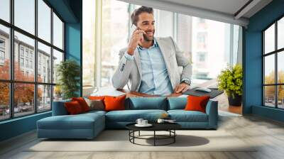 Thats just the news I was hoping to hear. Shot of a handsome young businessman talking on a cellphone in an office. Wall mural