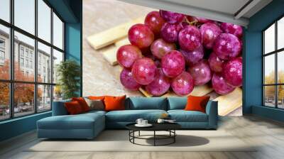 Fresh juicy pink and purple grape berries ripe in a bunch on wooden background. Wall mural