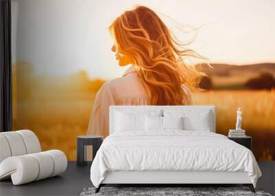 Happy woman standing with arms in the air looking at sunset. Carefree woman watching sunset in nature. Wall mural