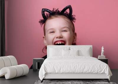 Portrait of surprised cute little girl standing isolated over pink background looking at camera Wall mural