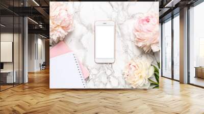 Mobile phone with a white and pink notebook and piony flowers on a marble background Wall mural