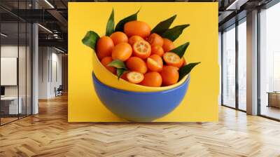 Kumquat fruits on a yellow background Wall mural