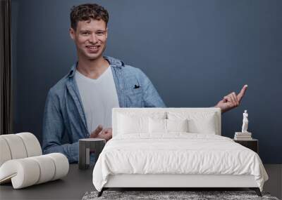 A man on a gray background shows aside Wall mural