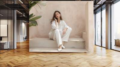 A photo of an attractive woman wearing white linen trousers and shoes Wall mural