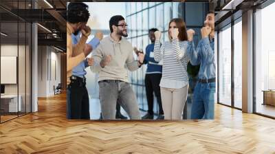 Business people celebrates and clench their fists in the air as a winning team Wall mural