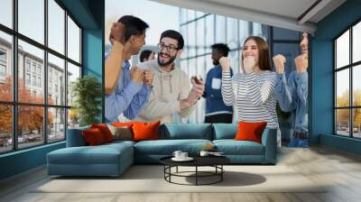 Business people celebrates and clench their fists in the air as a winning team Wall mural