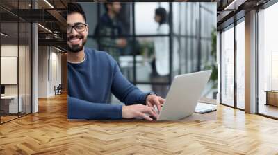 Businessman working on a laptop computer in the office Wall mural