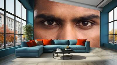 Close-up of the face and eyes of an Indian man in an emotional pose, eyes open Wall mural