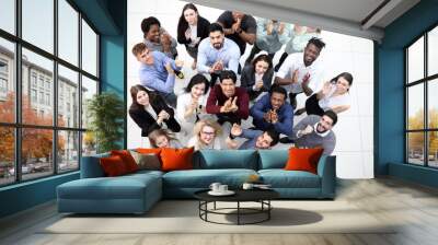 Diverse group of happy young people looking up and smiling at camera. Wall mural