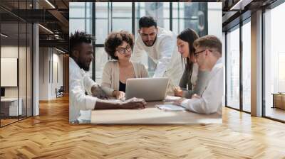 Employees working at computer together, discussing content Wall mural