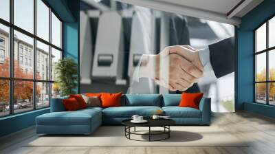 executives shaking hands in front of their manager and a colleague Wall mural