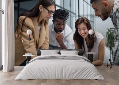 Group of young business people working together while standing in creative office Wall mural