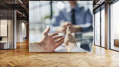 hands on the table in the office against the background of a blurred colleague, close-up Wall mural