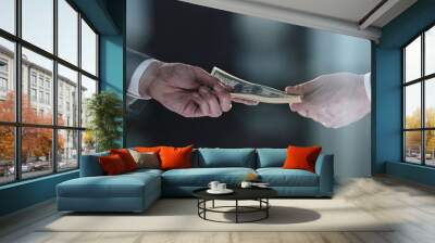 Money transfer between colleagues on a black background Wall mural